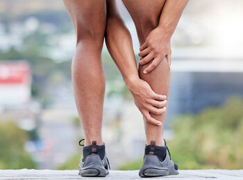 man holding his leg for calf muscle injuries