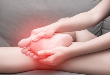 a girl having sesamoiditis pain on sofa 