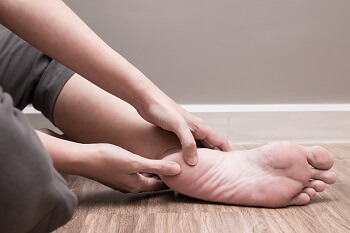 Young adult holding a painful heel