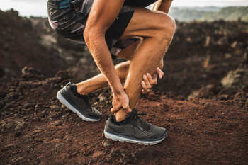 man having foot pain while running 