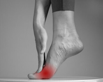 woman holding leg for running with metatarsalgia