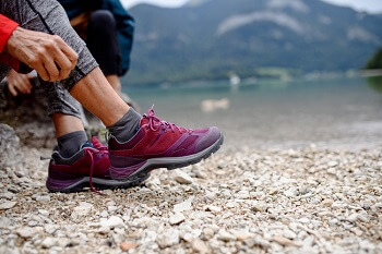 Putting on hiking shoes after shockwave therapy for foot pain